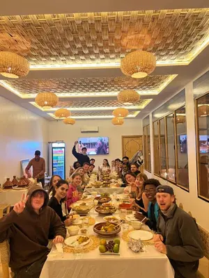 a group of people sitting at a long table at Rose Garden Dades in Kalaat MGouna