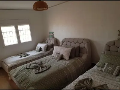 a bedroom with two beds and two windows at My HOME in Tinerhir