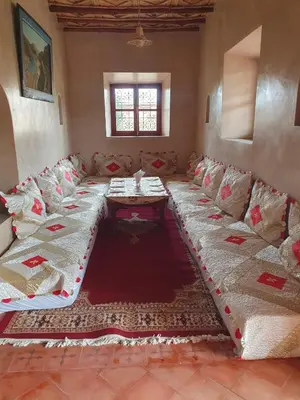 a living room with a long couch and a table at Kasbah Talala in Skoura