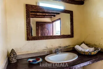 a bathroom with a sink and a mirror on the wall at Kasbah Talala in Skoura