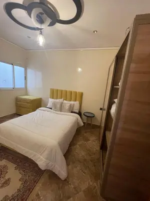 a bedroom with a large bed and a chandelier at حي الزهراء in Khenifra