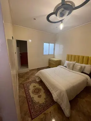a bedroom with a large bed and a chandelier at حي الزهراء in Khenifra