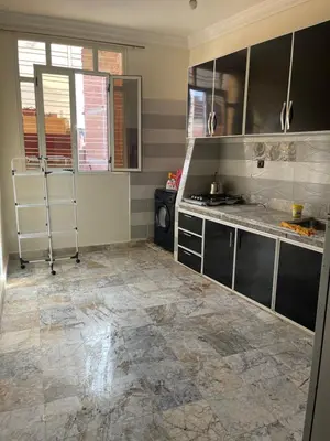 a kitchen with a tile floor and a counter top at حي الزهراء in Khenifra