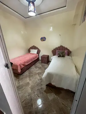 a bedroom with two beds and a couch at حي الزهراء in Khenifra