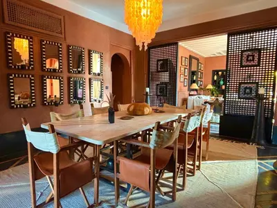 a dining room with a large wooden table and chairs at Palais Danka in Sraïri