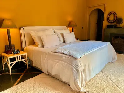 a bedroom with a large bed with white sheets and pillows at Palais Danka in Sraïri
