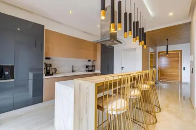 a kitchen with a bar with stools in it at Villa de plain-pied avec piscine chauffée à Marrakech in Marrakech