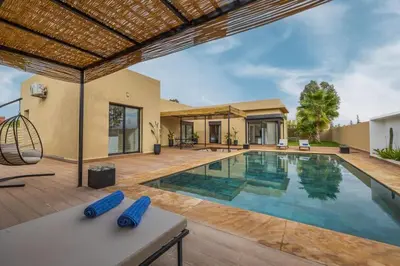 a house with a swimming pool and a house at Villa de plain-pied avec piscine chauffée à Marrakech in Marrakech
