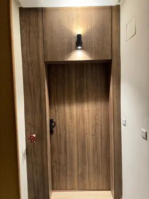 a wooden door with a light on top of it at Suite Bahiya 19 in Fès