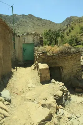 a stone building with a green door on a mountain at imintanoute in Kasba Aït Youdi