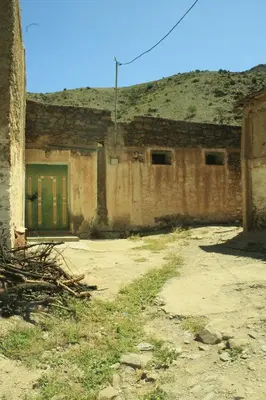 an old building with a green door in a field at imintanoute in Kasba Aït Youdi