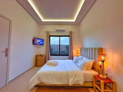 a bedroom with a large bed and a window at Villa soléa - Route Ouarzazate in Marrakech