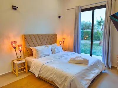 a bedroom with a bed and a large window at Villa soléa - Route Ouarzazate in Marrakech