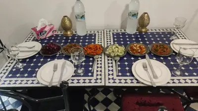 a table with plates and bowls of food on it at Dar Fez Arinas - Rooftop View - Central Fez in Fès