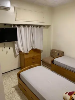 a small bedroom with two beds and a tv at Quartier labeta centre ville in Fès