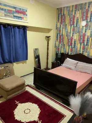 a bedroom with a bed and a chair and a rug at Quartier labeta centre ville in Fès