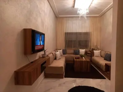 a living room with a couch and a flat screen tv at appartement meublé moderne in Fès