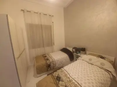 a small bedroom with a bed and a window at appartement meublé moderne in Fès