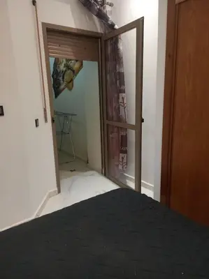 a bedroom with a door open to a room at appartement meublé moderne in Fès