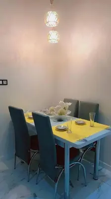 a dining room table with chairs and a yellow table cloth at appartement meublé moderne in Fès