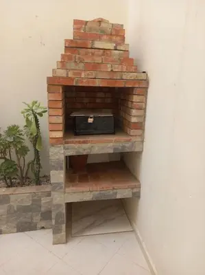 a brick fireplace in the corner of a room at appartement meublé moderne in Fès