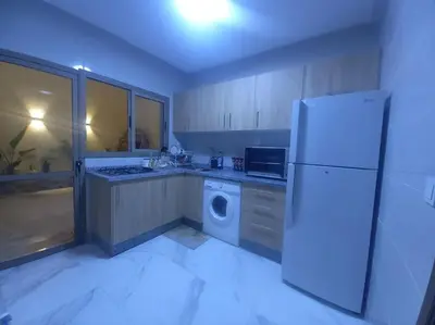 a kitchen with a refrigerator and a washing machine at appartement meublé moderne in Fès