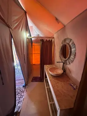 a bathroom in a tent with a sink and a mirror at Desert Bliss in Merzouga