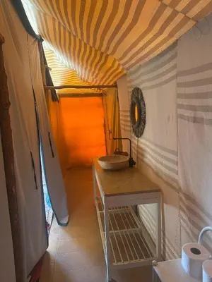 a bathroom with a sink and a table in a room at Desert Bliss in Merzouga