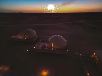 an overhead view of two domes in the ocean at sunset at Sahara Dome Camp in Merzouga
