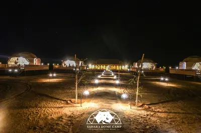a group of lights in a field at night at Sahara Dome Camp in Merzouga