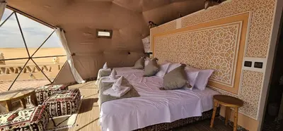 a bedroom with two beds in a tent at Sahara Dome Camp in Merzouga