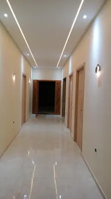 a corridor of a building with white walls and lights at Dar jama in Berrada