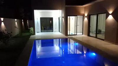 a house with a pool in front of it at night at Dar jama in Berrada
