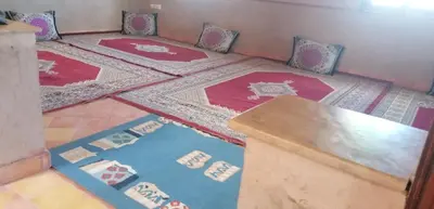 a room with red and blue rugs on the floor at DAR AGLMOUZ -Ighir aghzzaf- in Kalaat MGouna