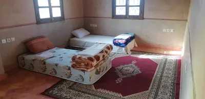 a room with a bed and a couch and windows at DAR AGLMOUZ -Ighir aghzzaf- in Kalaat MGouna