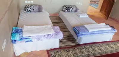 a room with three beds in a room at DAR AGLMOUZ -Ighir aghzzaf- in Kalaat MGouna
