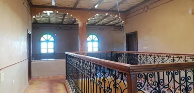 a staircase in a room with two windows at DAR AGLMOUZ -Ighir aghzzaf- in Kalaat MGouna