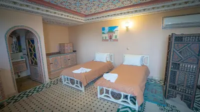a room with two beds in a room at Riad Golden Mansour in Meknès