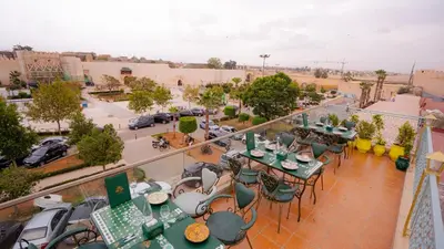 a balcony with tables and chairs and a street at Riad Golden Mansour in Meknès