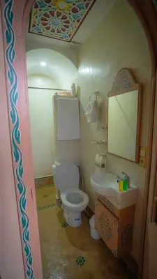 a bathroom with a toilet and a sink and a mirror at Riad Golden Mansour in Meknès