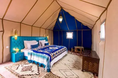 a bedroom with a bed in a tent at Luxury Merzouga Camp in Merzouga