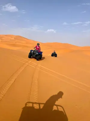two people riding on atvs in the desert at Luxury Merzouga Camp in Merzouga