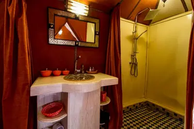 a bathroom with a sink and a mirror at Luxury Merzouga Camp in Merzouga