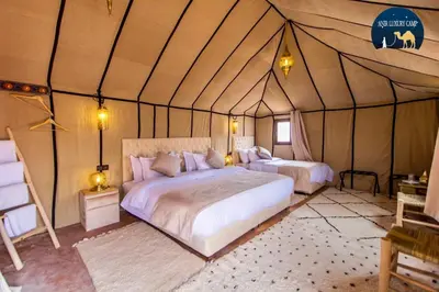 a bedroom with two beds in a tent at Luxury Merzouga Camp in Merzouga