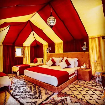 a bedroom with two beds in a tent style room at Luxury Merzouga Camp in Merzouga