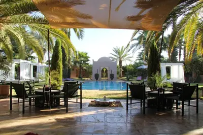 a patio with tables and chairs next to a pool at Palais Celoa in Marrakech