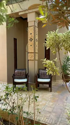 two chairs sitting on the side of a building at Palais Celoa in Marrakech