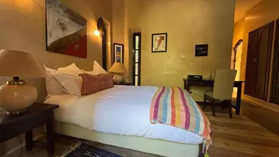 a bedroom with a bed and a desk with a desk at Palais Celoa in Marrakech