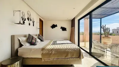 a bedroom with a bed and a balcony at Villa Sbaa Marrakech in Marrakech