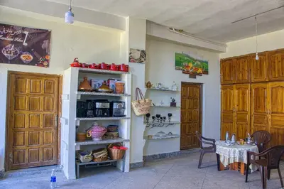 a room with a table and chairs and a kitchen at lmtounipalace in Ouarzazate